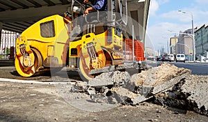 Asphalt compactor in the city. Road roller working at road construction site