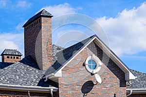 Asphalt . Decorative bitumen shingles on the roof of a brick house