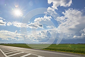 Asphalt highway with road markings on the background of blue sky