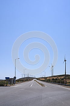 Asphalt highway with wind turbines on the horizon on the Greek island of Evia in Greece