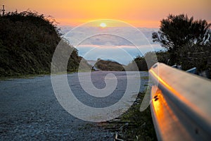 Asphalt mountain road high above the clouds during sunset. Location: Monchique Foia in Portugal