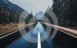 Asphalt mountain road in overcast rainy day in autumn