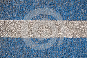 Asphalt is painted blue with a white stripe in the center. Road marking. Textured background. copy space. Top view.