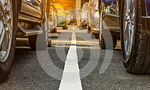 Asphalt parking lot of the airport or shopping mall. Car parking area for rent. Closeup wheel of many car parked at outdoor