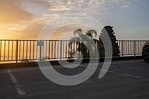 An asphalt parking lot for cars by the sea at sunrise