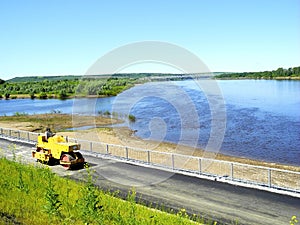 Asphalt paving machine on the river embankment