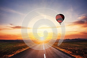 Asphalt road along and Colored ball in the sky at sunset