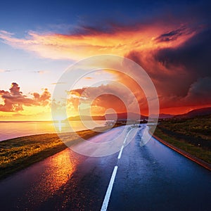 Asphalt road along the sea at sunset Iceland