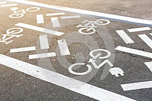 Asphalt road with bicycle and electric transport lane. Cycle and zero emission vehicles white sign on floor. Recreation