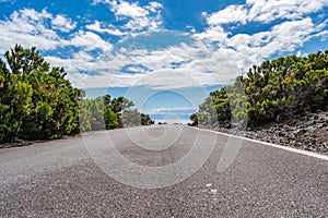 Asphalt road with blue sea and SÃ£o Jorge island on the horizon, Terceira - Azores PORTUGAL photo