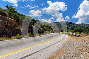 Asphalt road and cloudy sky in mountains on Crete island