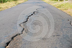 asphalt road cracked due to moving ground. earthquake.