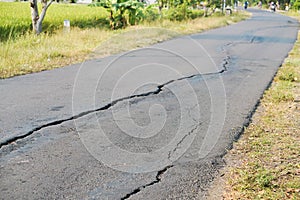 asphalt road cracked due to moving ground. earthquake.