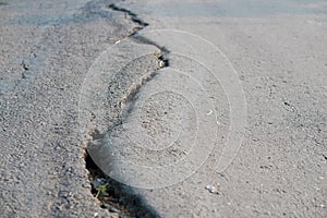 asphalt road cracked due to moving ground. earthquake.