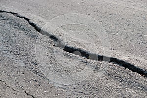 asphalt road cracked due to moving ground. earthquake.