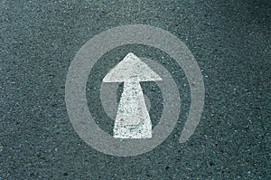 Asphalt road with drawn direction arrow