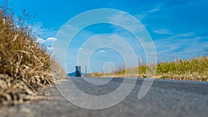 Asphalt road in a field at the end of which is a huge chimney of a nuclear power plant in West Germany on a beautiful summer day,