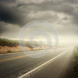 Asphalt road in forrest and rainclouds for transportation