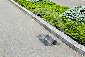 Asphalt road with grate drainage system.