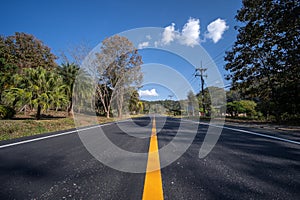 Asphalt road and green tree under blue sky. Road and mountain background. empty asphalt road , Country Road, Transportation