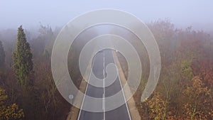 Asphalt road highway in an autumn fog forest aerial view