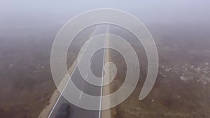 Asphalt road highway in an autumn fog forest aerial view