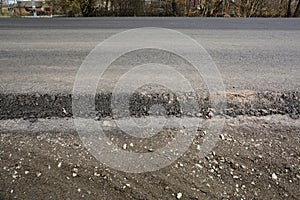 Asphalt road, highway, driveway construction and renovation. A close-up of an asphalt pavement structure with a broad surface