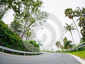 Asphalt road on hill with limit speed sign board sea island at phuket Thailand