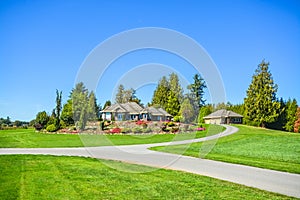 Asphalt road junction running over landscape with big farmer`s house on the hill