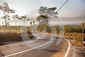 Asphalt road with a lane in the morning. A road with bends and road signs. A winding track