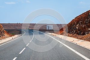Asphalt road leading to horizon trough the dusty landscape of Boa Vista island.