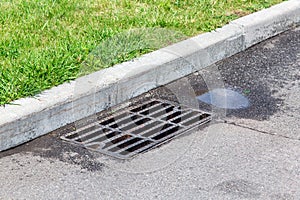 Asphalt road with manhole grille with drainage system.