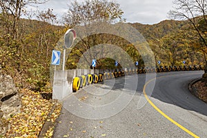 Asphalt road in the mountains of China, convex mirror and car wheels for safety