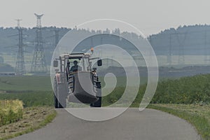 Asphalt road near Milesovice village in hot sunny summer with tractor