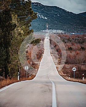 Asphalt road panorama in countryside on cloudy day. Road in forest under dramatic cloudy sky.