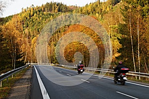 Asphalt road with a ride motorcycles in the autumn landscape