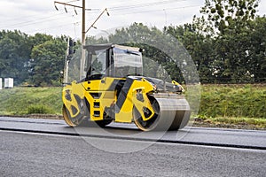 Asphalt road roller with heavy vibration roller compactor press new hot asphalt on the roadway on a road construction