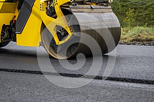 Asphalt road roller with heavy vibration roller compactor press new hot asphalt on the roadway on a road construction