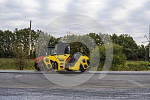 Asphalt road roller with heavy vibration roller compactor press new hot asphalt on the roadway on a road construction