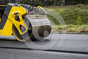 Asphalt road roller with heavy vibration roller compactor press new hot asphalt on the roadway on a road construction