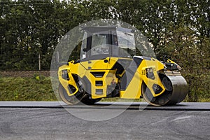 Asphalt road roller with heavy vibration roller compactor press new hot asphalt on the roadway on a road construction