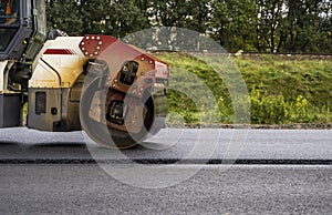 Asphalt road roller with heavy vibration roller compactor press new hot asphalt on the roadway on a road construction