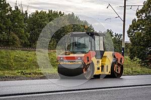 Asphalt road roller with heavy vibration roller compactor press new hot asphalt on the roadway on a road construction