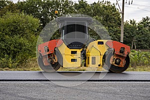 Asphalt road roller with heavy vibration roller compactor press new hot asphalt on the roadway on a road construction