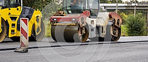 Asphalt road roller with heavy vibration roller compactor press new hot asphalt on the roadway on a road construction