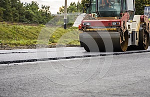 Asphalt road roller with heavy vibration roller compactor press new hot asphalt on the roadway on a road construction