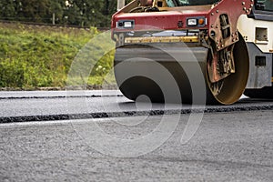 Asphalt road roller with heavy vibration roller compactor press new hot asphalt on the roadway on a road construction