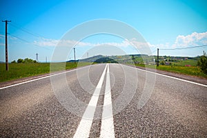 Asphalt road in a rural landscape. Road, village and sky