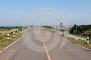 The asphalt road of the rural road is curved along the reservoir of the large dam