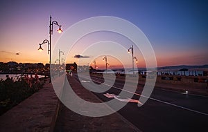 Asphalt road in sea bay leading to old town of Nessebar, Bulgaria, on background of colorful sky